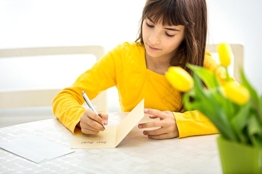 cute little girl making a card for her mom