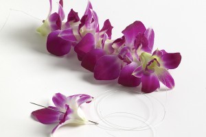 Add flower after flower with needle for lei. String flowers one by one for Hawaiian lei