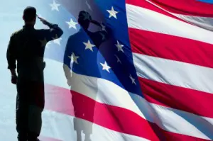Memorial day history with an American flag with two silhouettes of soldiers saluting it.