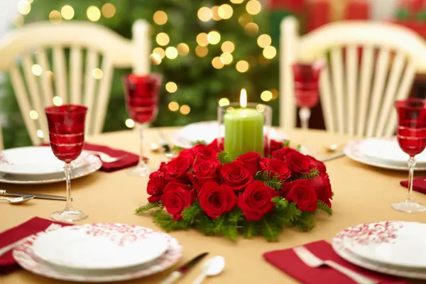 Christmas table centerpiece with red roses and evergreens