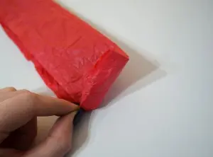 Pinching the Corner of the Tissue Paper to Begin Rolling