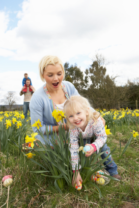 Family On Easter Egg Hunt In Daffodil Field