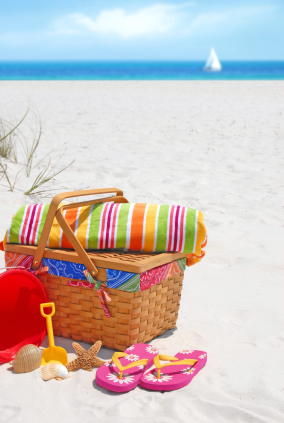 Pretty picnic basket and beach supplies at seashore