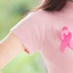 Close up Happy woman with a pink ribbon for Prevention Breast
