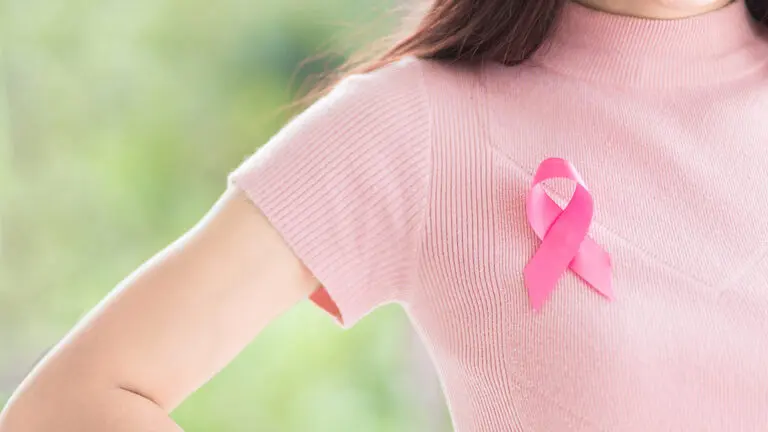 Close up Happy woman with a pink ribbon for Prevention Breast