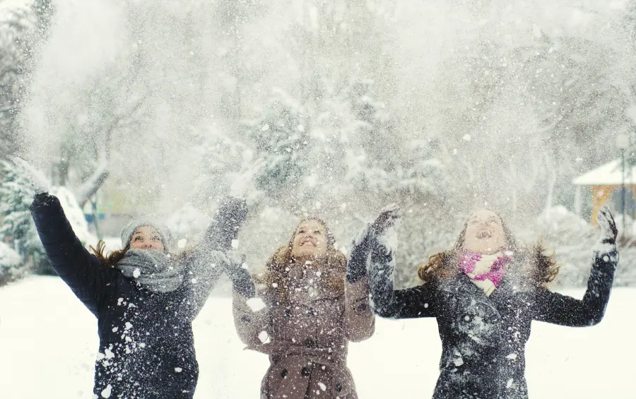 winter with girls throwing snow in the air