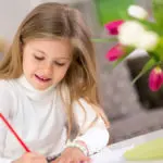 a photo of a girl coloring for mother's day