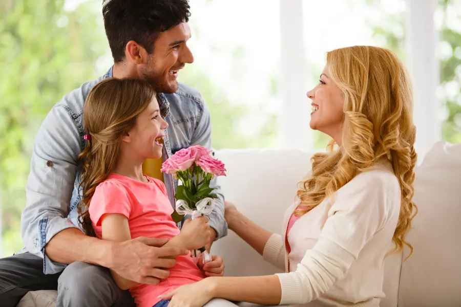 daughter-and-father-giving-mom-flowers-for-birthday
