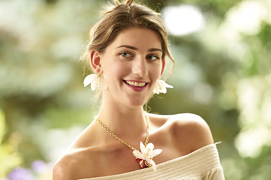 a photo of a girl wearing an orchid necklace