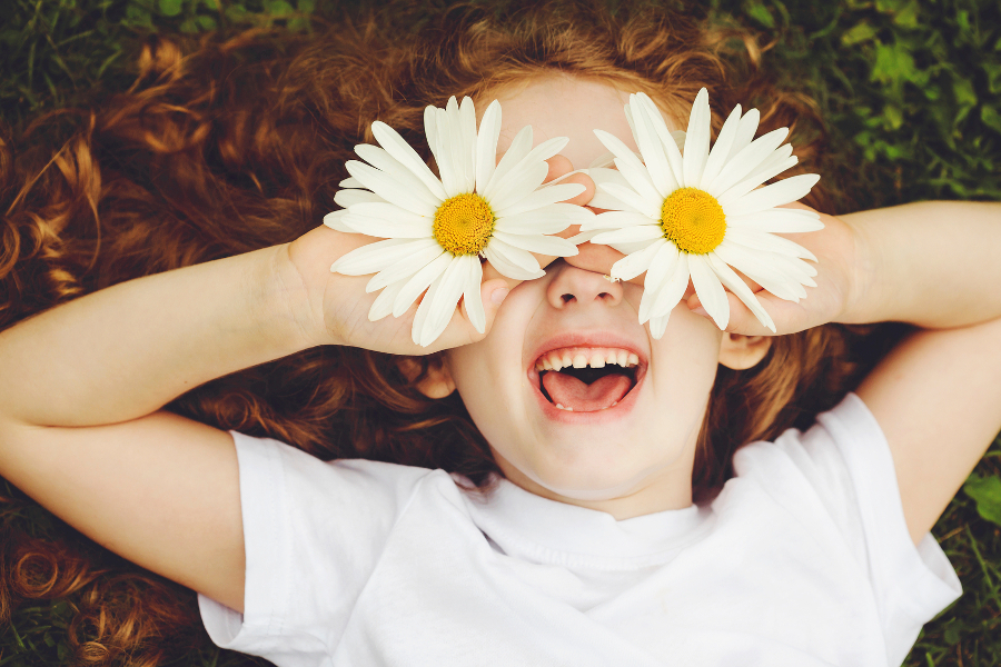 Daisy facts with little girl holding daisies