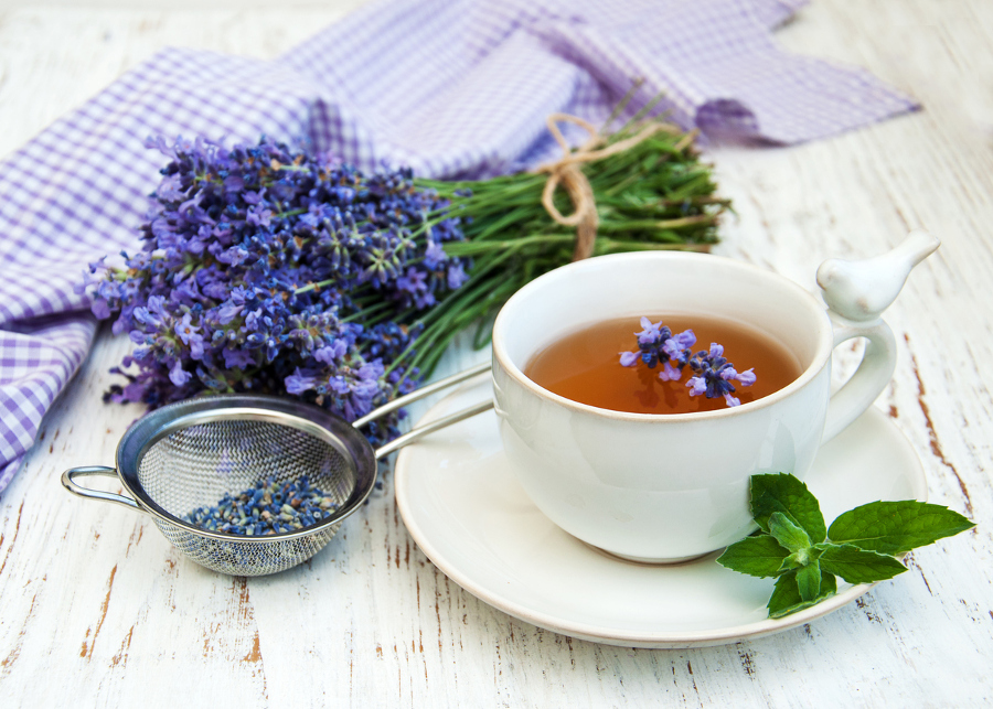 Cup of tea and lavender flowers on a old wooden background