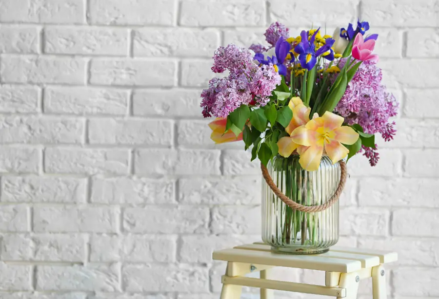 how to keep flowers alive with flowers in vase against brick background