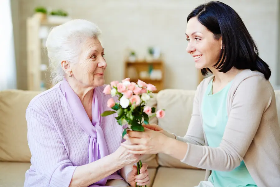 Woman giving her mom flowers for parents day