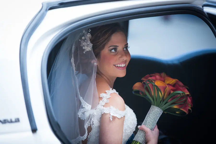 Bride with bouquet in car