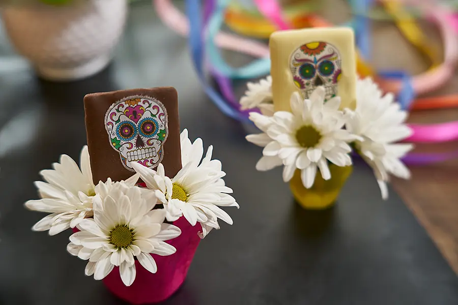 chocolate sugar skull treats inside white flower holders