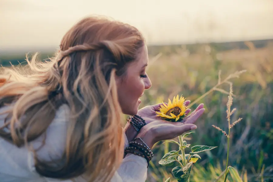 woman smelling sun flowers