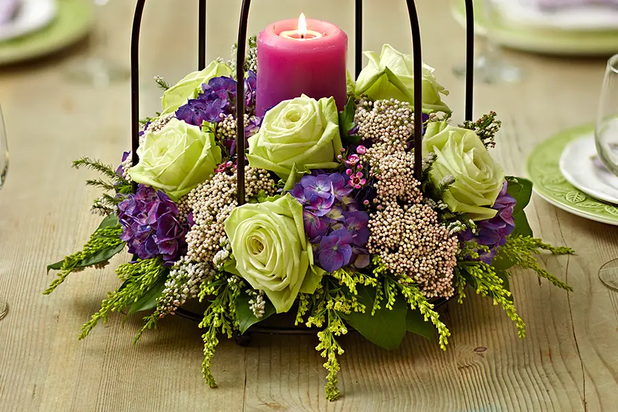 baby shower decor ideas with Bird cage centerpiece with hydrangeas, rice flowers, waxflowers, roses, and solidago.