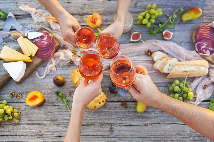 rose pairings with friends toasting at an outdoor meal