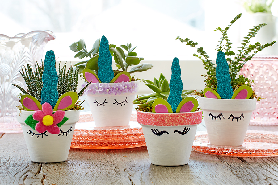Decoraciones de unicornio con minimacetas de unicornio llenas de plantas.