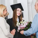 a photo of graduation flowers with parents giving thier graduate daughter flowers