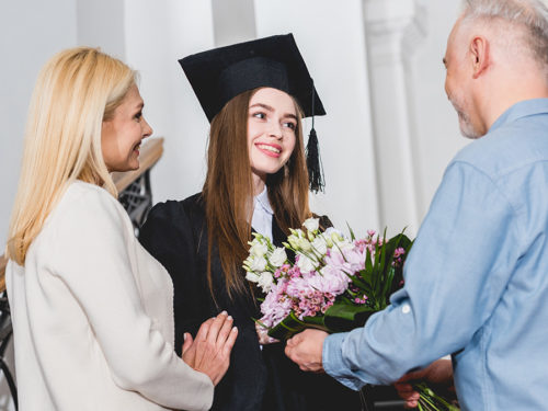 a photo of graduation flowers with parents giving thier graduate daughter flowers
