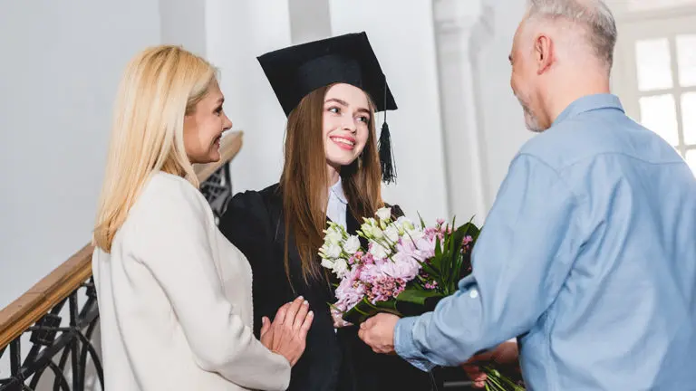 a photo of graduation flowers with parents giving thier graduate daughter flowers