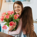 Girl giving mom flowers
