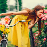 A photo of summer flowers with a woman smelling summer flowers