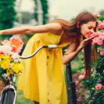 A photo of summer flowers with a woman smelling summer flowers