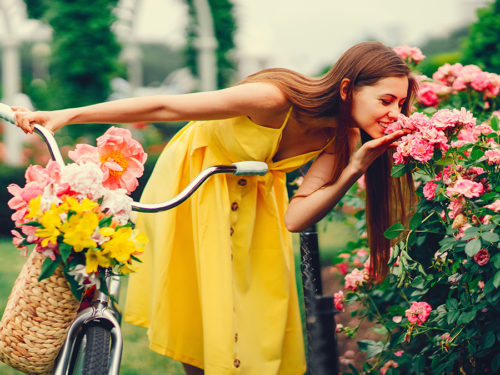A photo of summer flowers with a woman smelling summer flowers