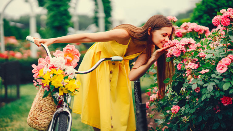 A photo of summer flowers with a woman smelling summer flowers