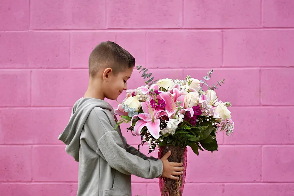 boy giving bouquet to mom
