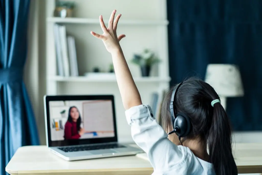 Girl raising hand at laptop