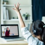 Girl raising hand at laptop