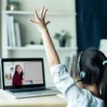 Girl raising hand at laptop