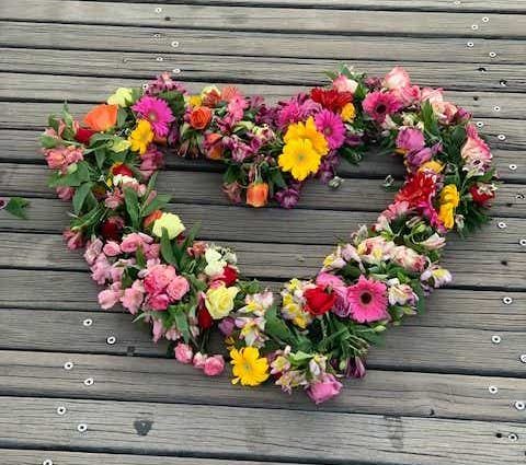 dying with heart-shaped flower wreath