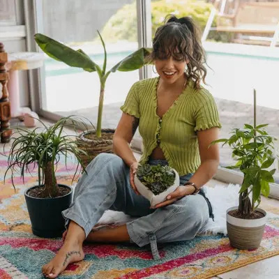naming your house plants with woman sitting amongst plants