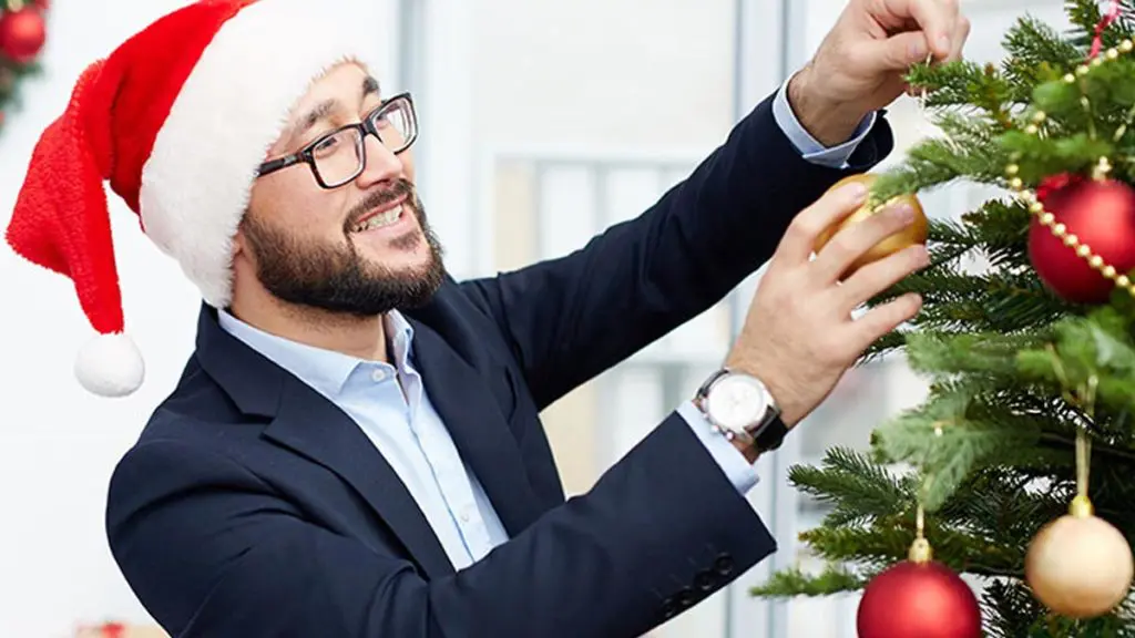 photo of a man decorating a christmas tree