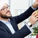 photo of a man decorating a christmas tree