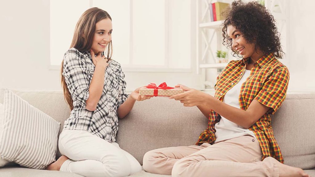 Excited woman getting gift from her friend