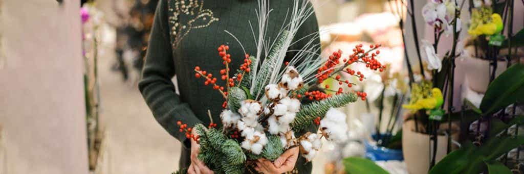 Holiday decor with woman holding winter floral arrangement