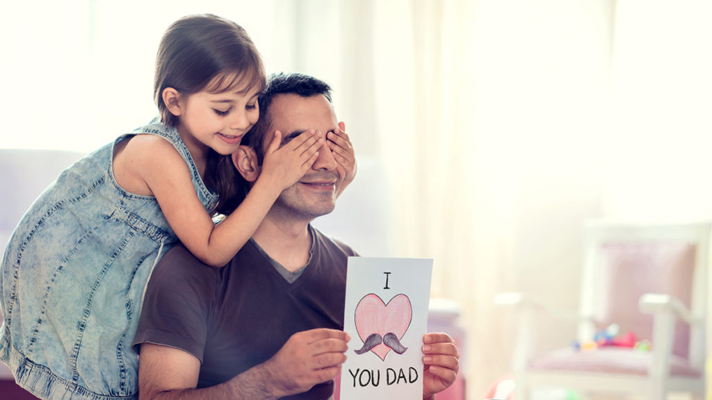 a photo of father's day card with daughter giving dad a card