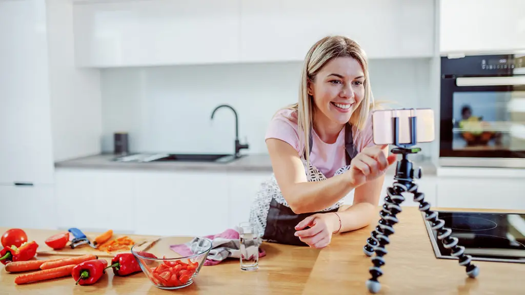 Woman in kitchen using smartphone