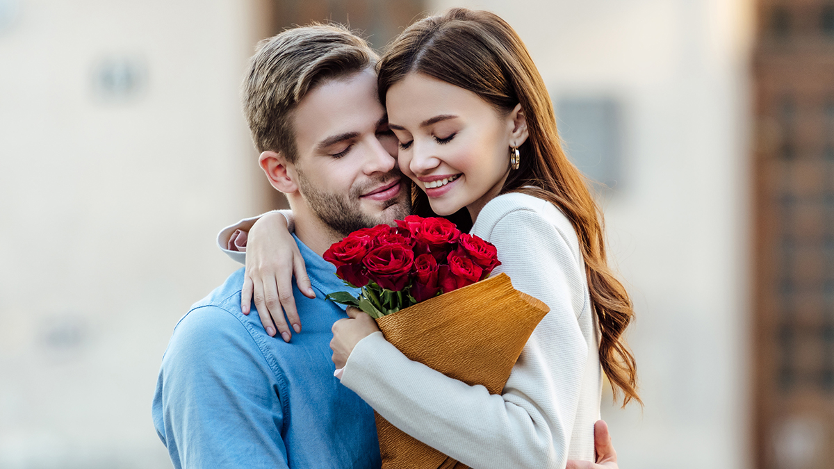 Couple embraces with bouquet of roses