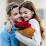 Couple embraces with bouquet of roses