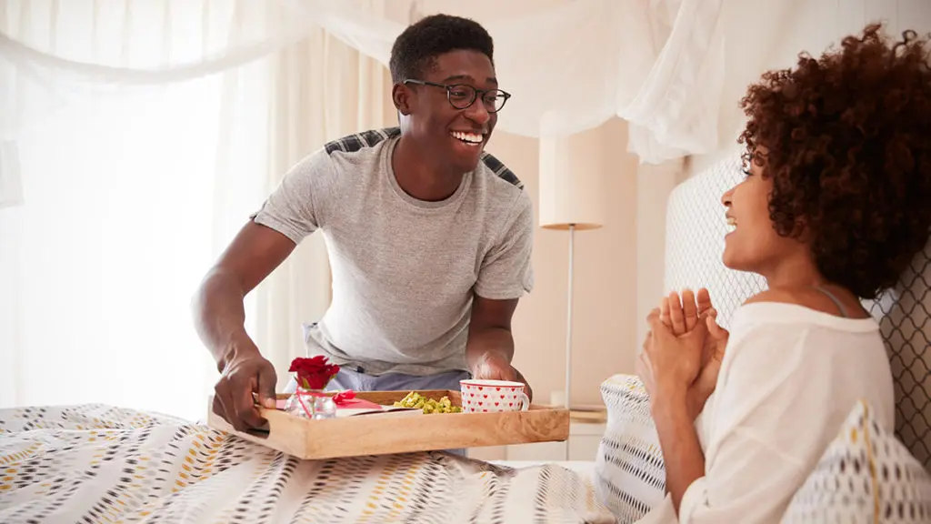 Valentine’s Day Gift Guide with Man giving woman breakfast in bed