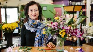 Photo of local florist Vivian Chang and an arrangement