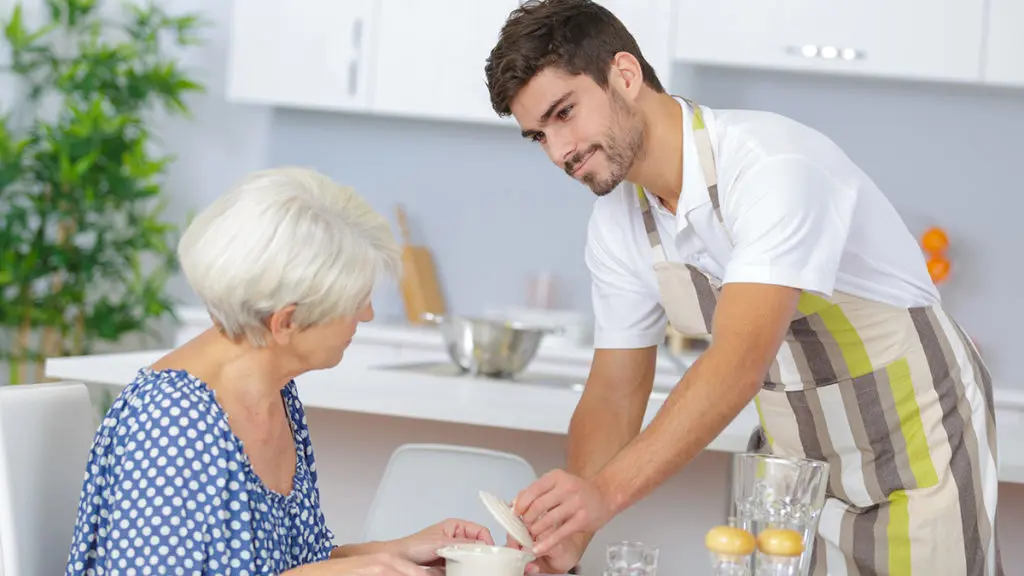 Waiter serving senior woman lunch