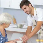 Waiter serving senior woman lunch