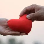 Two hands holding a plush heart